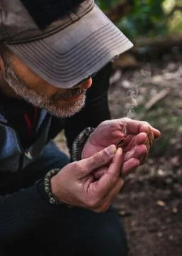Man making fire with tinder polypore fungus in a forest 写真素材