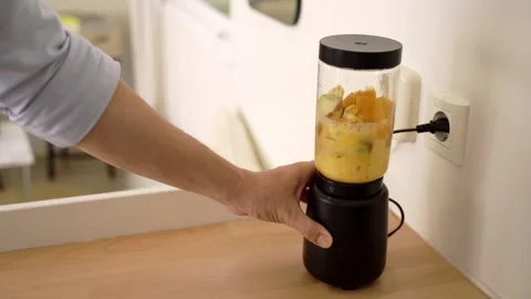 Man making a fruit smoothie Видео 261079360