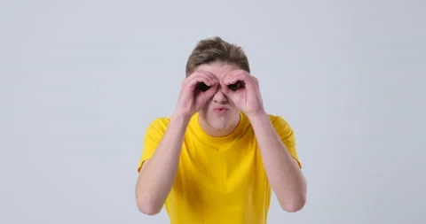 Man making funny binoculars hands gesture 库存影片 144958171