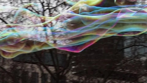 Man making giant multicolored soap bubbles with a loop rope. Stock-Footage 277571549