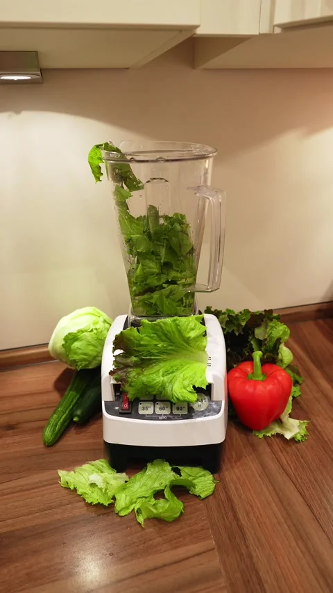 Man making a green smoothie with lettuce and vegetables Stock Footage 201265746