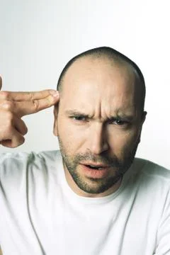 Man making gun gesture, pointing at temple, looking at camera Stock Photos