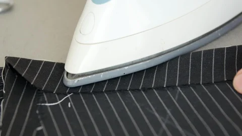 Man making handmade suit, he is ironing to the hem design in her studio, arts Stock Footage 127482443