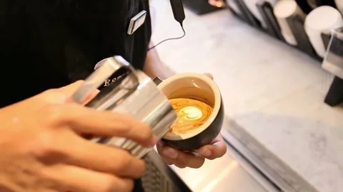 A man making latte art in a cup of coffee Stock Footage 293167536