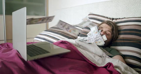 A man making money online while he sleeps. A man is awaking from by money flow Video stock 252145996