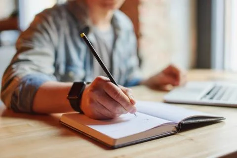 Man making notes in the textbook. Stock Photos