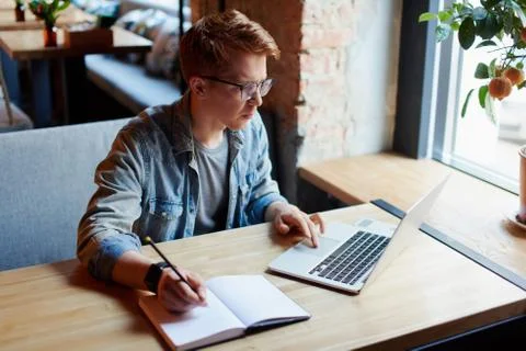 Man making notes in the textbook. Stock Photos