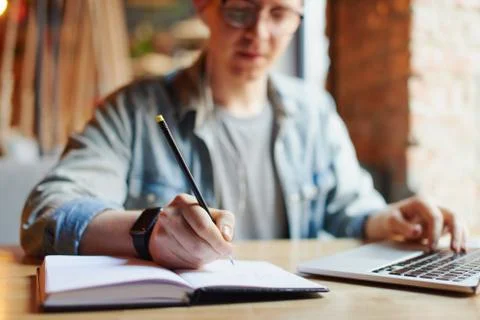 Man making notes in the textbook. Stock Photos