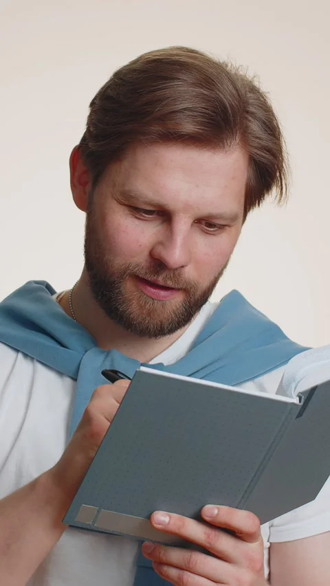 Man making notes, writing down thoughts with pen into notepad notebook diary, to Stock Footage 348596427