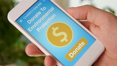 Man making an online donation environmental protection using charity applicaiton Stock Footage 77410280