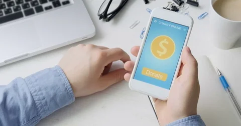 Man making an online donation using charity applicaiton on smartphone Stock Footage 78502178