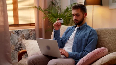 Man Making Online Payment Holding Credit Card And Shopping Online Using Laptop Stock Footage 147003434