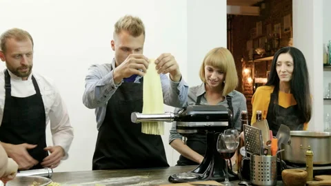 Man making pasta from dough using pasta machine at culinary class. 4K Stock Footage 91379063