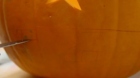 A Man Making A Pattern To Carve A Pumpkin For The Coming Event That Will Stock Footage 124667968