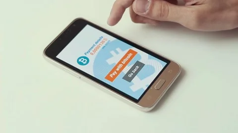Man making a payment with bitcoins cryptocurrency using his smartphone 스톡 동영상 106670697