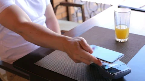 Man making payment transaction with his mobile phone to waiter in modern cafe Stock Footage 105561351