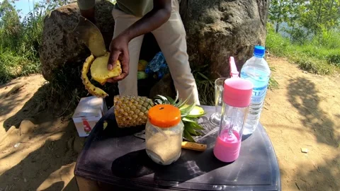 A man making a pineapple shake at the top of little Adams Peak, HD Stockbeeldmateriaal 141862223