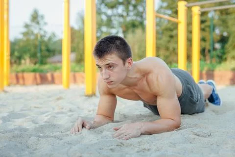 Man is making a plank during workout. Outdoor gym background Stock Photos