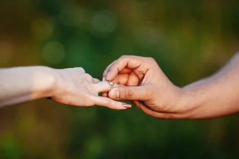 Man making proposal with the ring to his girlfriend. Put ring on hand Stock Photos
