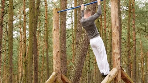 Man making pull-up in the forest - gym outdoors Stock Footage 70717298