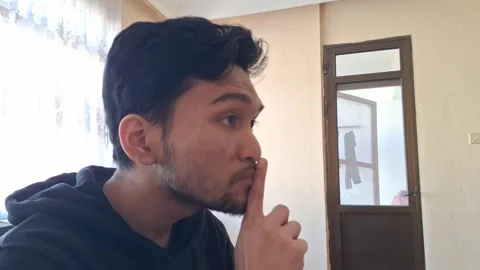 Man Making a Quiet Gesture Indoors Stock Footage 330759942