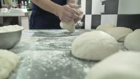 Man making raw sourdough buns and a placing them in the countertop Stock Footage 240786452