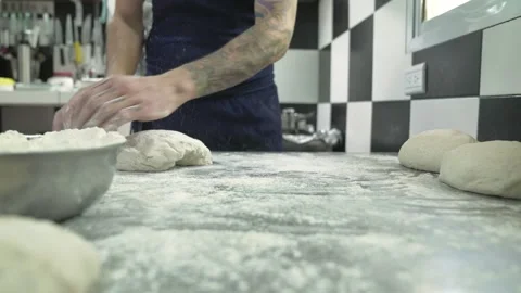 Man making raw sourdough buns and a placing them in the countertop Stock Footage 240786460
