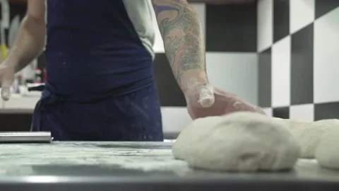 Man making raw sourdough buns and a placing them in the countertop Stock Footage 240786881