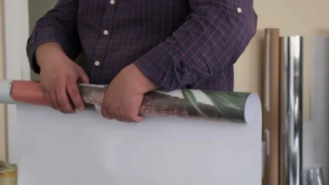 A man making a roll of large paper. Man making the poster roll. Stock Footage