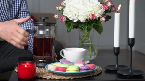 Man making romantic dinner with macarons and flowers Stock Footage 168946293