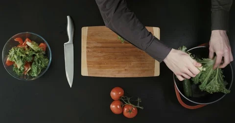 Man is making a salad. Top view on the man's hands. Stock Footage