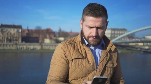 Man making selfie by smartphone app on the background of the river, sunny day 動画素材 72709770