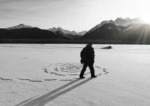 Man making snow circles at sunset Stock Photos