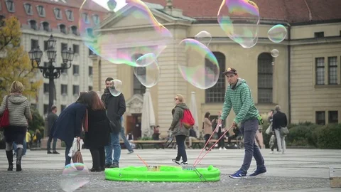 A Man making a Soap Bubbles on Gendarmenmarkt in Berlin - autumn Stock Footage 81975390