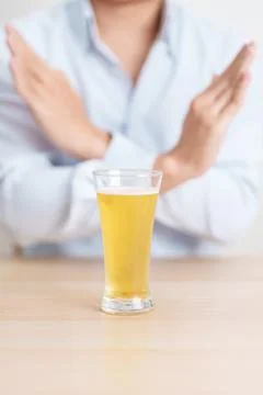 Man making stop hand gesture to refuse a glass of Beer, Healthy man say no .. Stock Photos