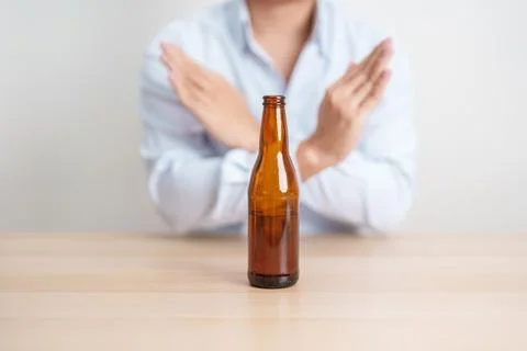 Man making stop hand gesture to refuse a bottle of Beer, Healthy man say no.. Stock Photos