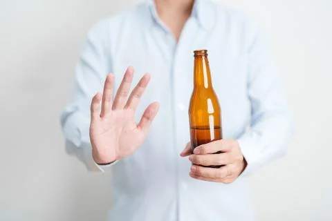 Man making stop hand gesture to refuse a bottle of Beer, Healthy man say no.. Stock Photos