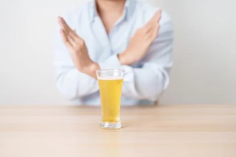 Man making stop hand gesture to refuse a glass of Beer, Healthy man say no .. Stock Photos