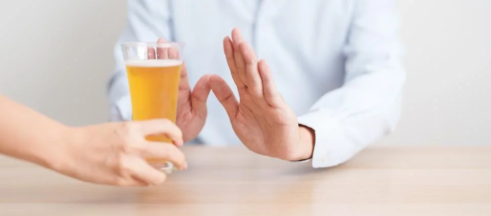 Man making stop hand gesture to refuse a glass of Beer, Healthy man say no .. Stock Photos