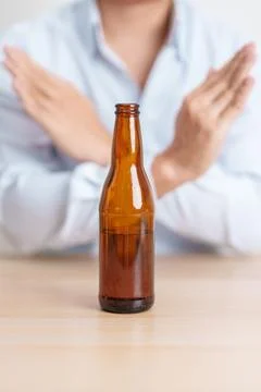 Man making stop hand gesture to refuse a bottle of Beer, Healthy man say no.. Stock Photos