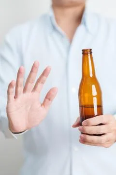Man making stop hand gesture to refuse a bottle of Beer, Healthy man say no.. Stock Photos