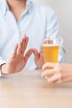 Man making stop hand gesture to refuse a glass of Beer, Healthy man say no .. Stock Photos