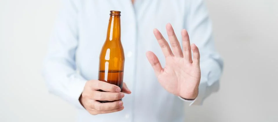 Man making stop hand gesture to refuse a bottle of Beer, Healthy man say no.. Stock Photos