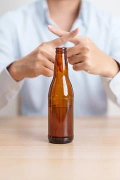 Man making stop hand gesture to refuse a bottle of Beer, Healthy man say no.. Stock Photos