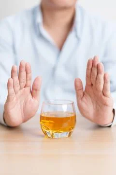 Man making stop hand gesture to refuse a glass of whiskey, Healthy man say .. Stock Photos
