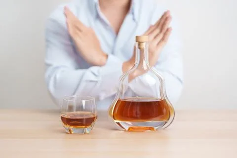 Man making stop hand gesture to refuse a glass of Cognac, Healthy man say n.. Stock Photos