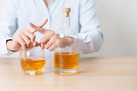 Man making stop hand gesture to refuse a glass of whiskey, Healthy man say .. Stock Photos