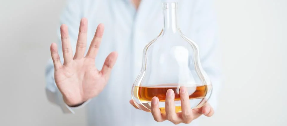 Man making stop hand gesture to refuse a bottle of Cognac, Healthy man say .. Stock Photos
