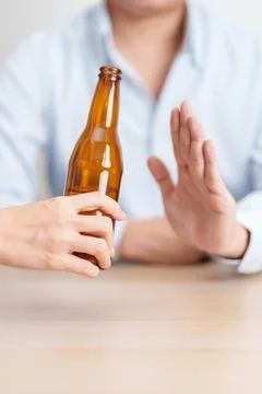Man making stop hand gesture to refuse a bottle of Beer, Healthy man say no.. Stock-Fotos