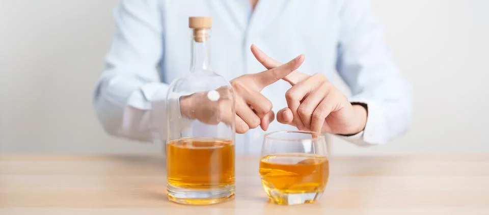 Man making stop hand gesture to refuse a glass of whiskey, Healthy man say .. Stock-Fotos